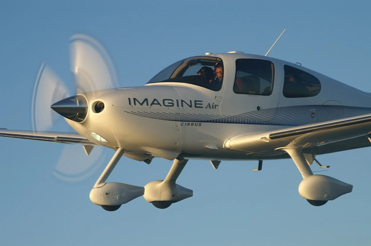 Cirrus airplane in flight against a clear blue sky